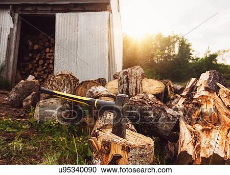 Stock Image - USA, Maine, Knox, Axe beside shed at sunset. Fotosearch