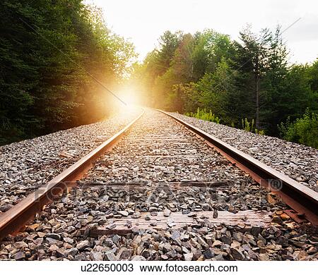 Stock Image - USA, Maine, Knox, Railroad track at sunset. Fotosearch