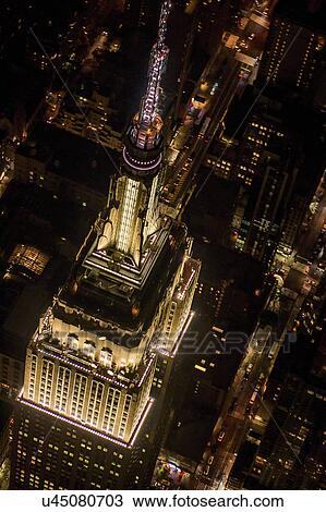 Stock Image - USA, New York, New York City, Aerial view of illuminated Empire State Building at night. Fotosearch