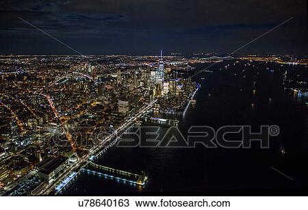 Stock Image - USA, New York, New York City, Aerial view of illuminated skyline at night. Fotosearch