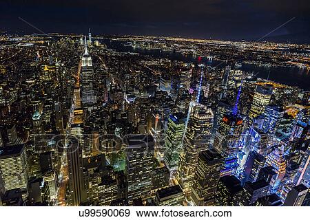 Stock Photo - USA, New York, New York City, Manhattan, Aerial view of illuminated skyline at night. Fotosearch