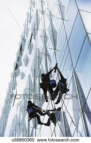 USA, New York, New York City, Windows washers cleaning glass facade of office building View Large Photo Image Stock Image - USA, New York, New York City, Windows washers cleaning glass facade of office building. Fotosearch