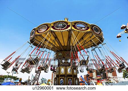 Stock Image - USA, New York State, New York City, Brooklyn, Carousel in amusement park. Fotosearch