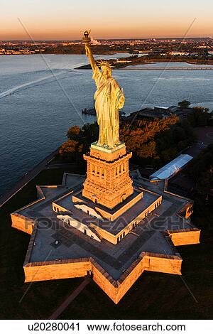 Stock Image - USA, New York State, New York City, Aerial view of Statue of Liberty at sunrise. Fotosearch