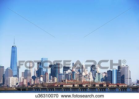 Stock Image - USA, New York State, New York City, Manhattan, City panorama seen across Hudson River. Fotosearch