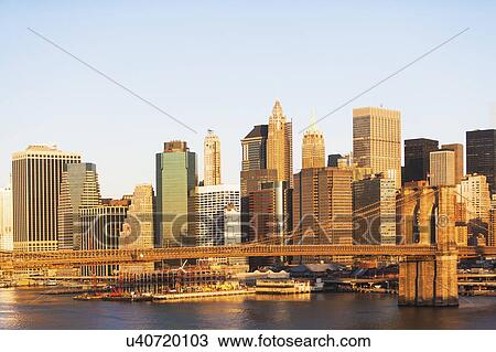 Stock Image - USA, New York State, New York City, Manhattan, City panorama with Brooklyn Bridge. Fotosearch