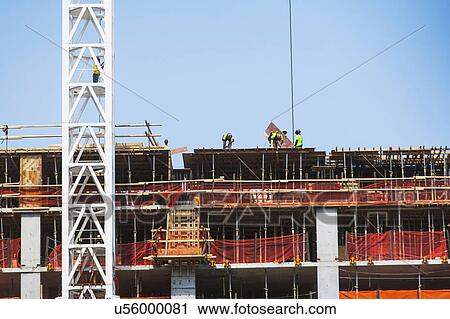 Stock Image - USA, New York State, New York City, Manhattan, People working on construction site. Fotosearch