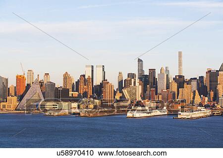 Stock Image - USA, New York State, New York City, Manhattan, City panorama seen across Hudson River. Fotosearch