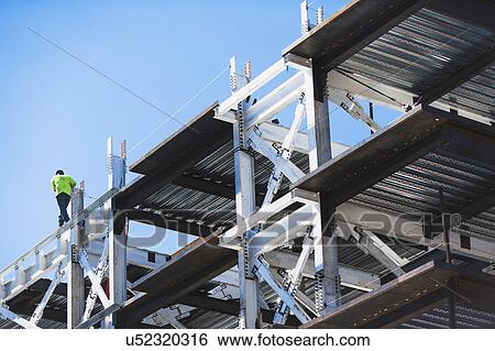 Stock Photograph - USA, New York State, New York City, Manhattan, Mid adult man working on construction site. Fotosearch