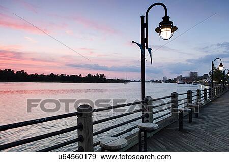 Stock Photo - USA, North Carolina, Wilmington, Riverbank at sunset. Fotosearch