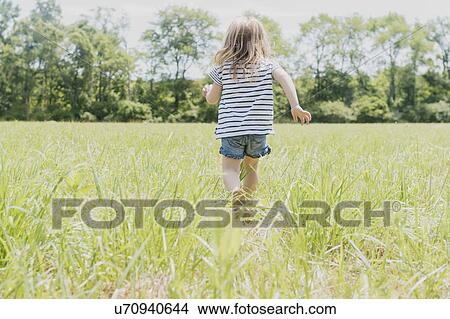 Picture - USA, Pennsylvania, Washington Crossing, Girl (2-3) walking on green field. Fotosearch