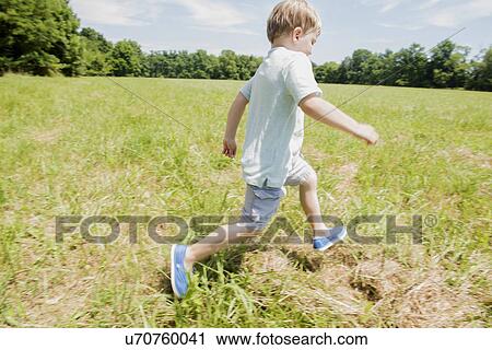 Stock Image - USA, Pennsylvania, Washington Crossing, Boy (4-5) running on green field. Fotosearch