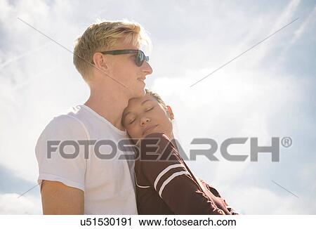 Woman and boyfriend against sunlit blue sky View Large Photo Image Stock Image - Woman and boyfriend against sunlit blue sky. Fotosearch