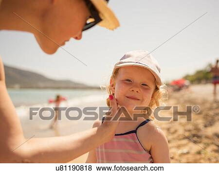 Woman applying suncream to daughter's face on beach, Altea, Alicante Province, Spain View Large Photo Image Stock Photo - Woman applying suncream to daughter's face on beach, Altea, Alicante Province, Spain. Fotosearch