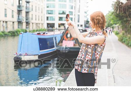 Woman by canal taking photograph, London, UK View Large Photo Image Stock Photo - Woman by canal taking photograph, London, UK. Fotosearch