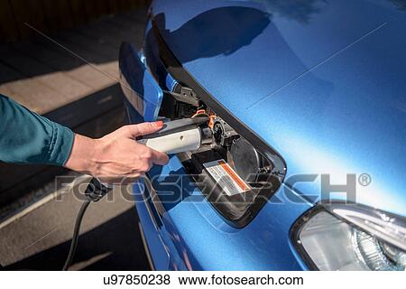 Woman charging electric car from charging point, close up detail View Large Photo Image Stock Photo - Woman charging electric car from charging point, close up detail. Fotosearch