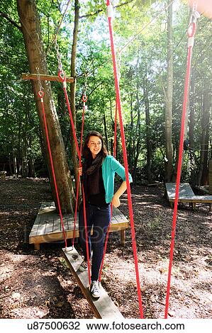 Woman crossing rope bridge on assault course View Large Photo Image Stock Image - Woman crossing rope bridge on assault course. Fotosearch
