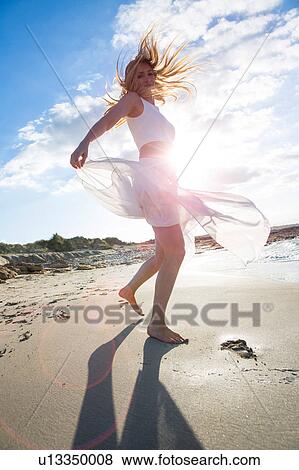 Stock Photo - Woman dancing on beach. Fotosearch