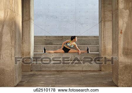 Stock Photo - Woman doing splits on steps. Fotosearch