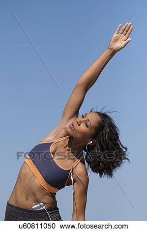 Woman exercising against blue sky View Large Photo Image Stock Image - Woman exercising against blue sky. Fotosearch