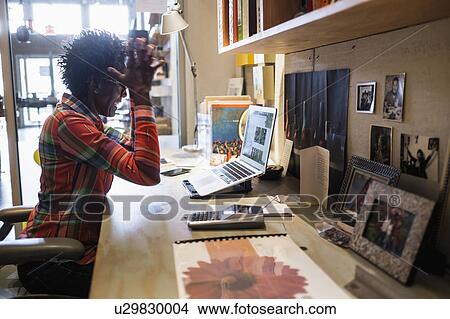 Woman gesturing in front of laptop in office View Large Photo Image Picture - Woman gesturing in front of laptop in office. Fotosearch
