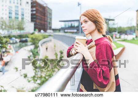 Woman holding cup looking away, London, UK View Large Photo Image Stock Image - Woman holding cup looking away, London, UK. Fotosearch