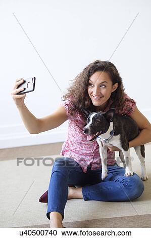 Woman holding dog, taking selfie View Large Photo Image Stock Image - Woman holding dog, taking selfie. Fotosearch