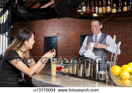 Woman in bar talking with bartender View Large Photo Image Picture - Woman in bar talking with bartender. Fotosearch
