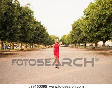 Woman in red dress standing in park, Alicante, Spain View Large Photo Image Stock Photography - Woman in red dress standing in park, Alicante, Spain. Fotosearch