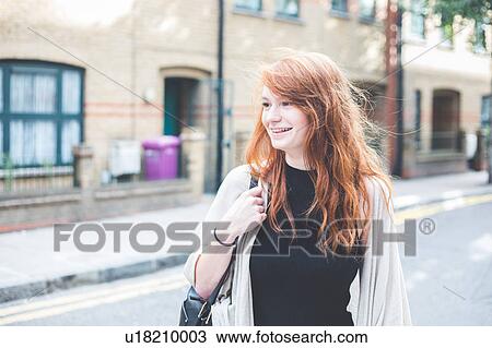 Woman in urban area looking away smiling, London, UK View Large Photo Image Stock Image - Woman in urban area looking away smiling, London, UK. Fotosearch