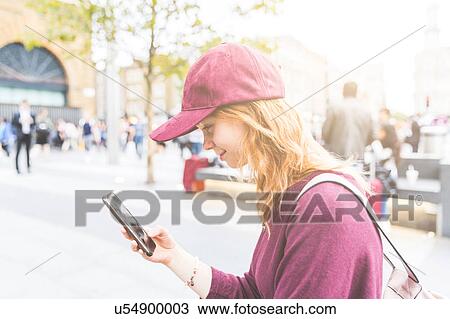 Woman in urban area using smartphone smiling, London, UK View Large Photo Image Stock Image - Woman in urban area using smartphone smiling, London, UK. Fotosearch