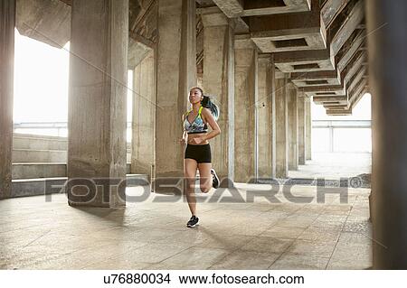 Picture - Woman jogging in urban area. Fotosearch