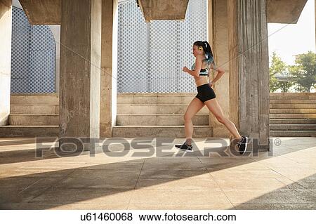 Stock Photo - Woman jogging in urban area. Fotosearch