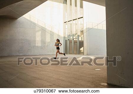 Stock Photo - Woman jogging in urban area. Fotosearch