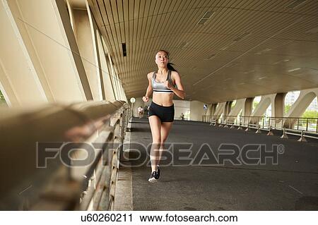 Woman jogging on elevated walkway View Large Photo Image Stock Image - Woman jogging on elevated walkway. Fotosearch