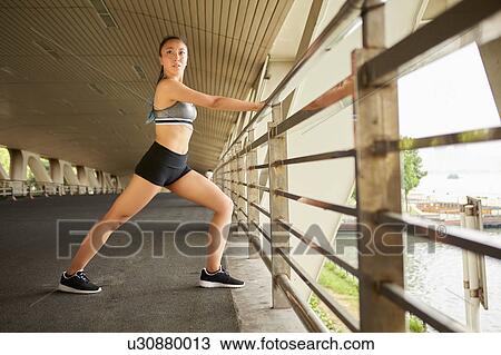 Stock Image - Woman leaning against railings looking away. Fotosearch