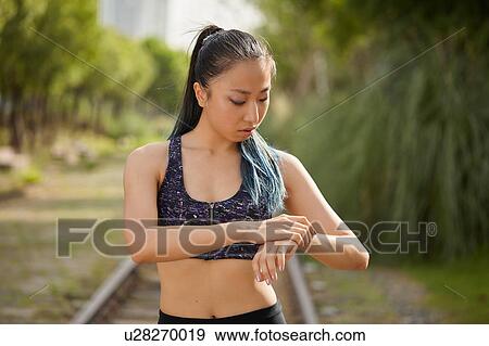 Woman on railway track looking at watch View Large Photo Image Stock Photo - Woman on railway track looking at watch. Fotosearch