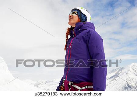 Woman on snow-covered mountain looking up smiling, Saas Fee, Switzerland View Large Photo Image Stock Image - Woman on snow-covered mountain looking up smiling, Saas Fee, Switzerland. Fotosearch