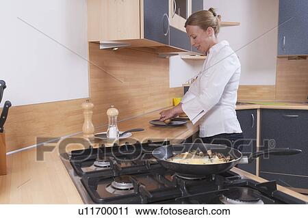 Woman preparing scrambled eggs for breakfast View Large Photo Image Stock Image - Woman preparing scrambled eggs for breakfast. Fotosearch