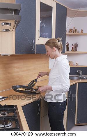 Woman preparing scrambled eggs for breakfast View Large Photo Image Stock Photo - Woman preparing scrambled eggs for breakfast. Fotosearch