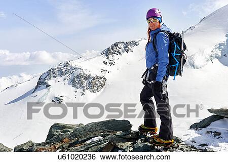 Stock Photograph - Woman standing in top of snow covered mountain, Saas Fee, Switzerland. Fotosearch