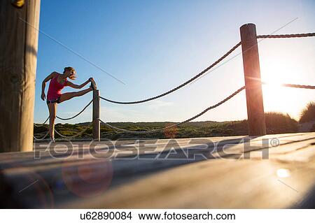Woman stretching on boardwalk View Large Photo Image Picture - Woman stretching on boardwalk. Fotosearch