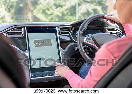 Woman using graphical display in electric car View Large Photo Image Stock Image - Woman using graphical display in electric car. Fotosearch