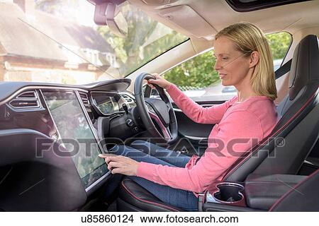 Woman using satellite navigation system in electric car View Large Photo Image Picture - Woman using satellite navigation system in electric car. Fotosearch