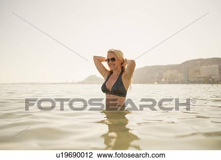 Woman wading waist up in sea, Alicante, Spain View Large Photo Image Stock Image - Woman wading waist up in sea, Alicante, Spain. Fotosearch