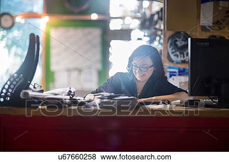 Stock Photo - Woman working at counter in shop. Fotosearch