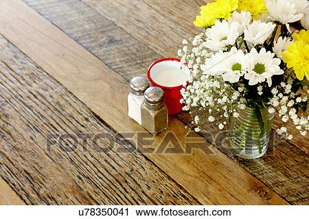 Wooden table in coffee shop with flower arrangement and salt & pepper View Large Photo Image Stock Image - Wooden table in coffee shop with flower arrangement and salt & pepper. Fotosearch