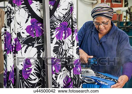 Worker ironing dress in garment factory View Large Photo Image Stock Image - Worker ironing dress in garment factory. Fotosearch
