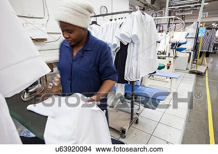 Worker ironing shirt in garment factory View Large Photo Image Picture - Worker ironing shirt in garment factory. Fotosearch