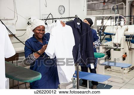 Worker ironing shirt in garment factory View Large Photo Image Stock Image - Worker ironing shirt in garment factory. Fotosearch